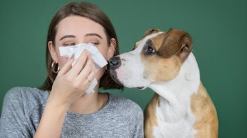 Mulher com sintomas de alergia a cachorro - Photoboyko/iStock