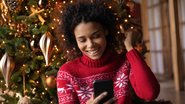 Jovem adulta enviando mensagens de Natal para os amigos - fizkes/iStock