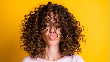 Os cabelos cacheados caem bem com uma variedade de cortes ousados e elegantes. - Imagem: Deagreez / iStock