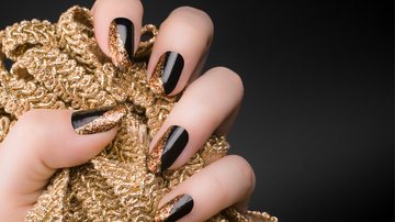 As unhas pretas com glitter são sinônimo de sofisticação. - Imagem: Baiajaku/iStock