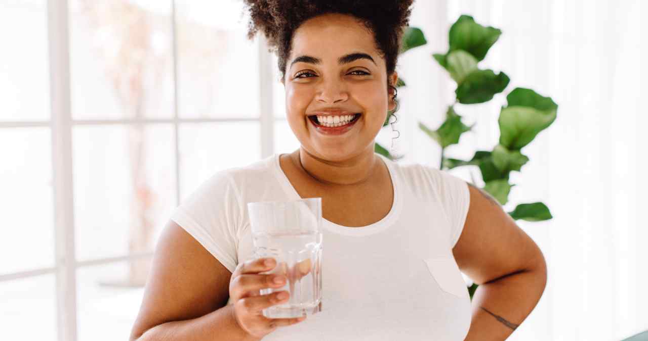 projeto verão: mulher posando segurando um copo cheio de água