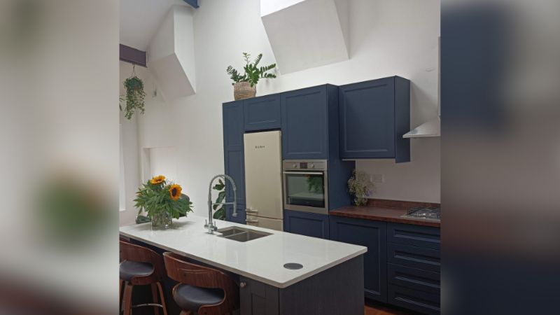 A cozinha de Maxine conta com móveis planejados da cor azul.