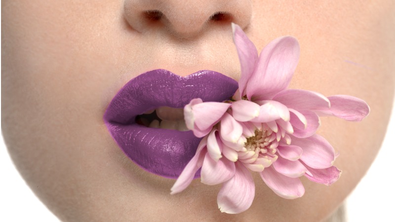 mulher usando batom na cor roxa nos lábios