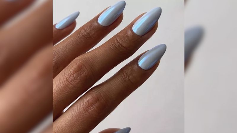 A nail art metálico está com tudo em 2023! Com a base em azul claro ela fica ainda mais estilosa.