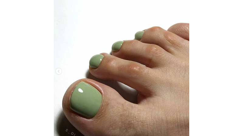 Unhas dos pés pintadas em tom verde militar.
