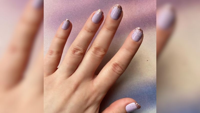 O lilás é uma das principais cores para unhas em 2023. Por que não combiná-lo com glitter?