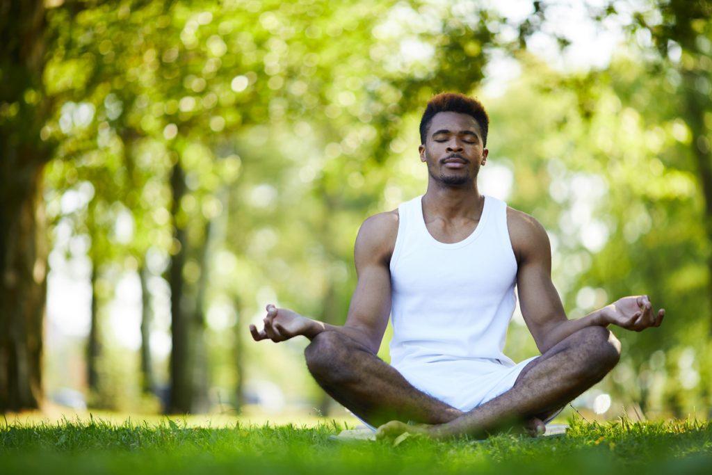homem praticando meditação a em parque