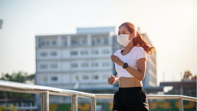 mulher se exercitando ao ar livre com mascara de protecao contra o coronavirus covid 19