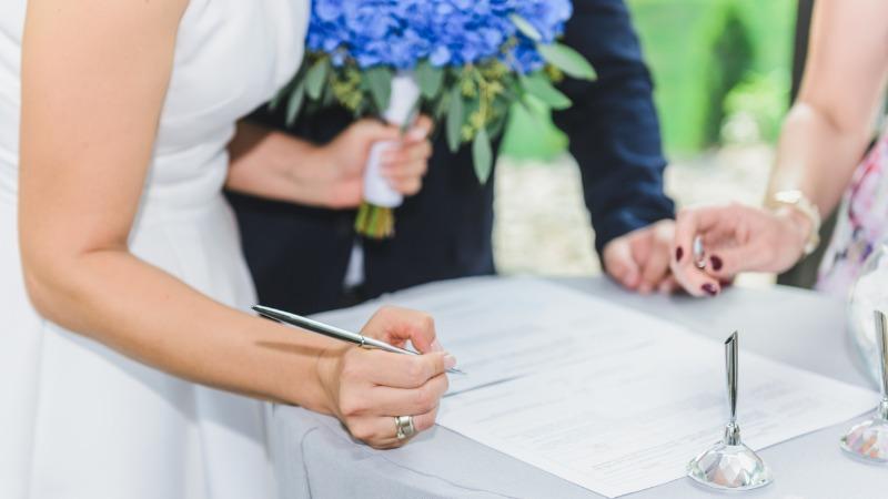 Noiva assinando certidão de casamento
