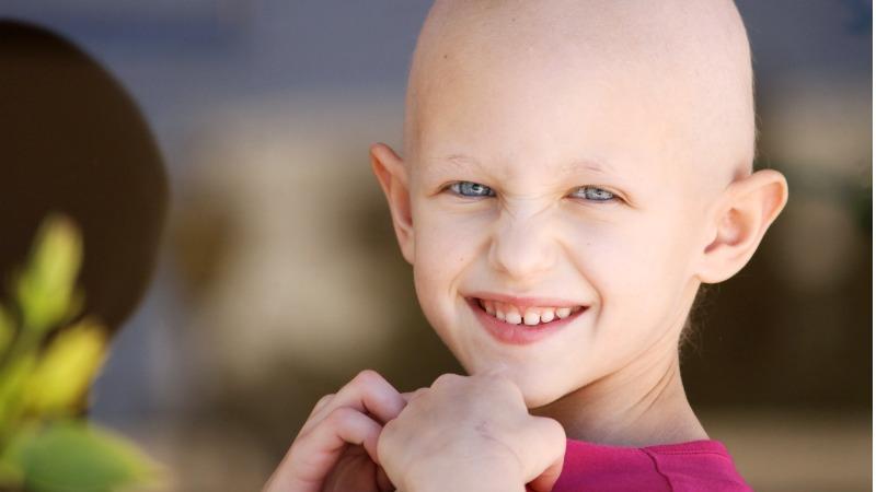 menina rindo em tratamento para leucemia infantil