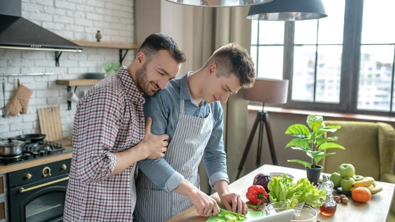 casal gay fazendo comida juntos