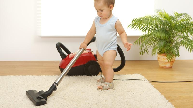 bebê limpando tapete para ilustrar Tapete para quarto de bebê: 7 dicas para escolher o ideal