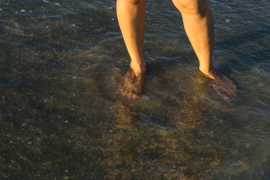 pés na água poluída