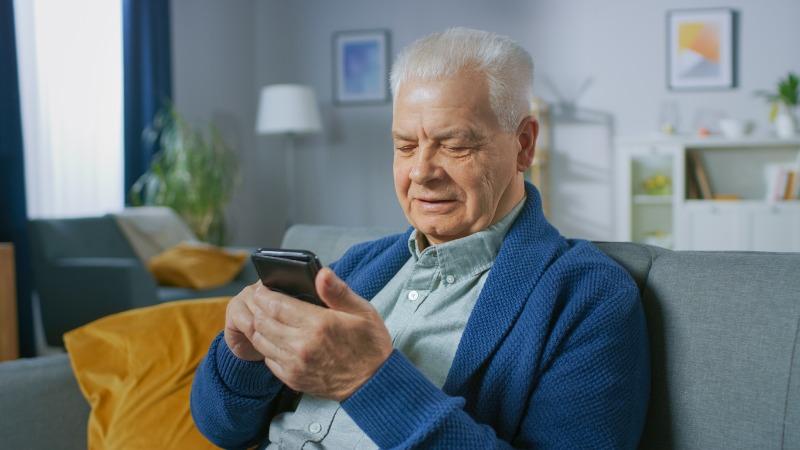 homem idoso lendo noticia no celular